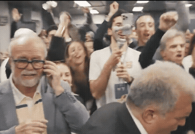 Man With Glasses Talking On Cell Phone In Crowd GIF