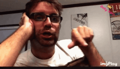 Man With Glasses Talking On Cell Phone In Front Of Castro Poster GIF