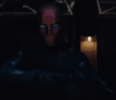 Man With Glowing Eyes Standing By Lit Candle GIF