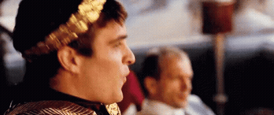 Man With Gold Laurel Wreath Sitting Beside Another Man GIF