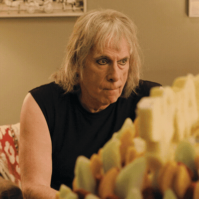 Man With Gray Hair Sitting At Table Full Of Food GIF