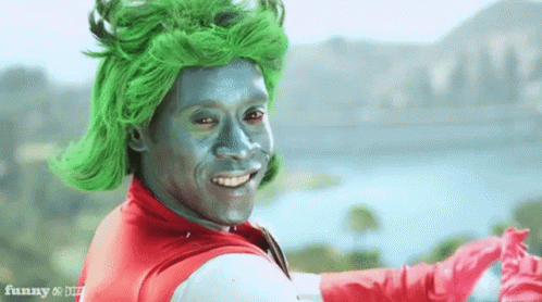 Man With Green Hair And Silver Face Paint In Superhero Costume GIF
