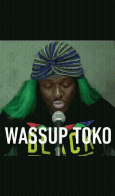 Man With Green Hair Singing Into Microphone Wearing Turban GIF