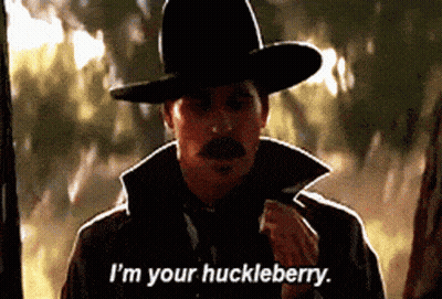 Man With Gun And American Flag Saying I'm Your Huckleberry GIF