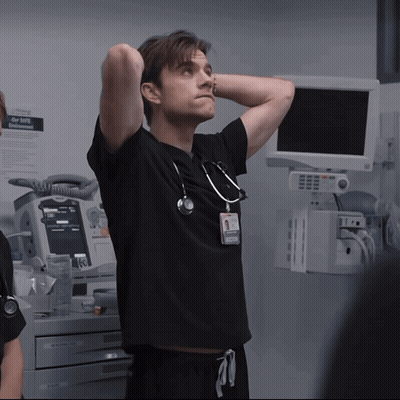 Man With Hands Behind Head In Front Of Emergency Monitor GIF