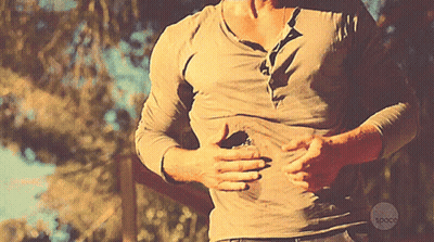 Man With Hands On Stomach And Space Logo Shirt GIF