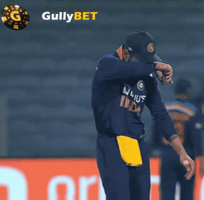 Man With Head Down In Front Of Gullybet Ad GIF