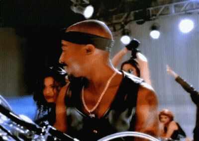 Man With Headband And Necklace Playing Drums On Stage GIF