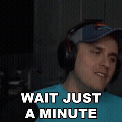 Man With Headphones and Baseball Cap Says Wait Just a Minute