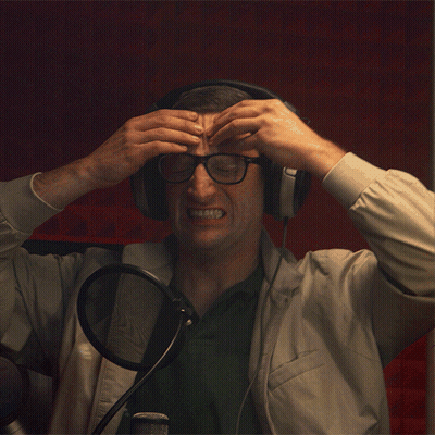 Man With Headphones And Glasses Holding Head In Pain GIF
