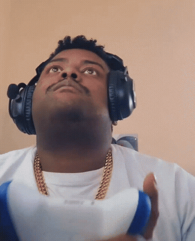 Man With Headphones And Gold Chain Holding PlayStation Controller GIF