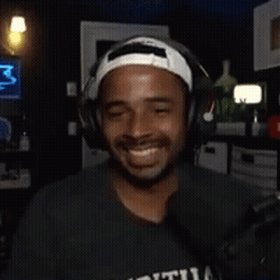 Man With Headphones And Headband Smiling In Dark Room GIF