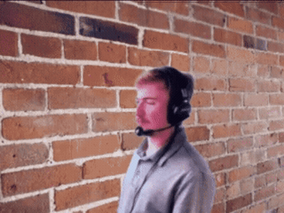 Man With Headphones and Microphone by Brick Wall
