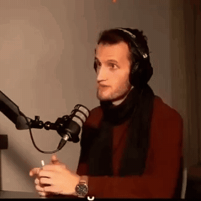 Man With Headphones And Scarf Talking Into Mic GIF