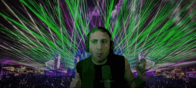 Man With Headphones At Microphone In Front Of Crowd With Green And Purple Lasers GIF