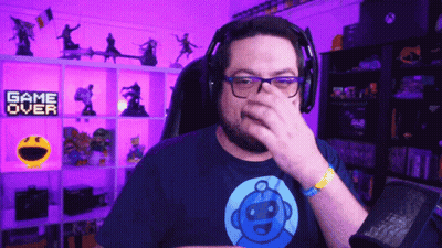 Man With Headphones Covering Nose In Front Of Game Over Sign GIF