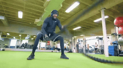 Man With Headphones Doing Battle Rope Exercises GIF