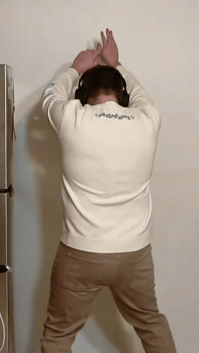 Man With Headphones Head Against Wall GIF