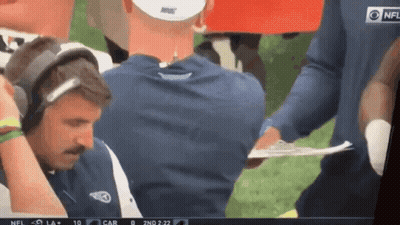 Man With Headphones Holding Clipboard In Front Of NFL Logo GIF