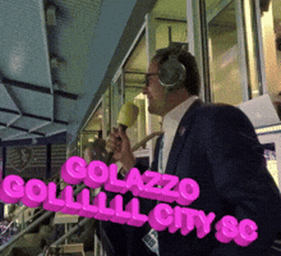 Man With Headphones Holding Microphone In Front Of Golazzo Sign GIF