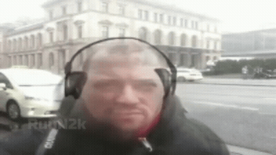 Man With Headphones In Front Of Building GIF