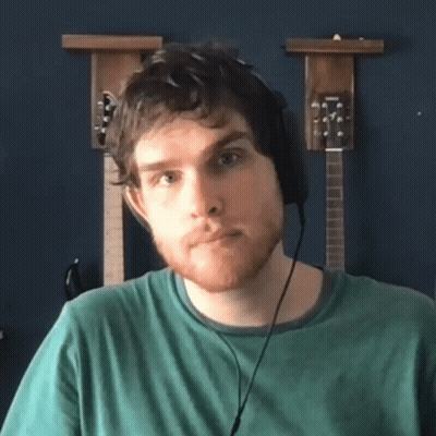 Man With Headphones In Front Of Guitars On Wall GIF