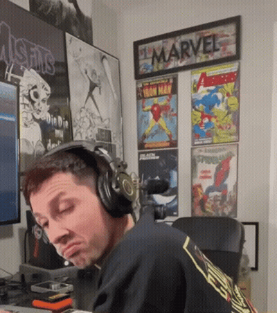 Man With Headphones In Front Of Marvel Posters GIF