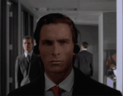 Man With Headphones Looking At Camera In Hallway GIF