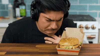 Man With Headphones Looking At Hamburger In Box GIF