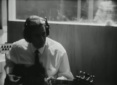 Man With Headphones Playing Guitar In Dark Room GIF