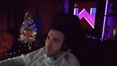 Man With Headphones Sitting By Christmas Tree GIF