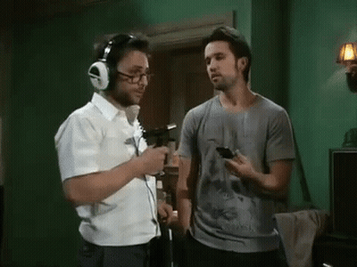 Man With Headphones Talking To Man With Cell Phone GIF