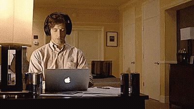 Man With Headphones Working On Apple Laptop GIF