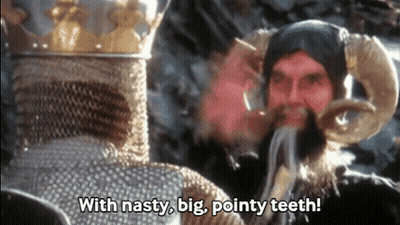 Man With Horns Talking To Bearded Man With Nasty Big Pointy Teeth GIF