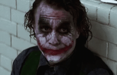 Man With Joker Makeup Sitting Next To Wall GIF