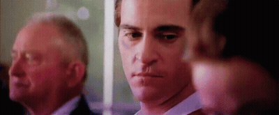 Man With Knife In Mouth Standing Next To Another Man GIF