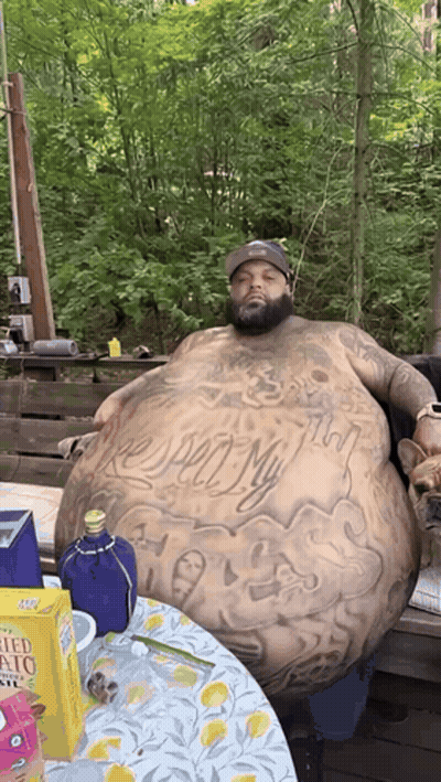 Man With Large Belly Sitting At Table With Potato Chips GIF