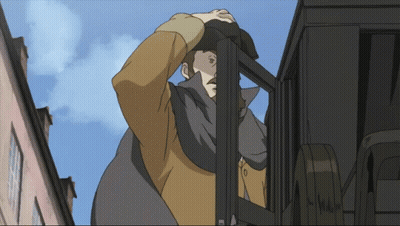 Man With Letter M On Chest In Front Of Building GIF