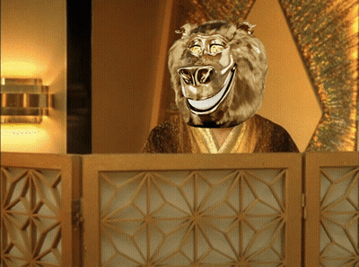Man With Lion Head Behind Wooden Fence GIF