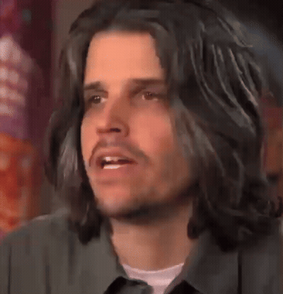 Man With Long Black Hair And Beard Looking At Camera GIF