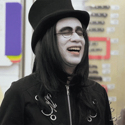 Man With Long Black Hair And Glasses In Top Hat Laughing GIF