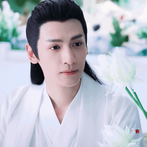 Man With Long Black Hair Holding White Flower GIF