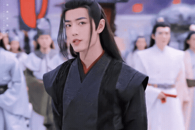 Man With Long Black Hair Standing In Crowd GIF