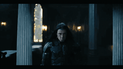 Man With Long Black Hair Standing In Dark GIF