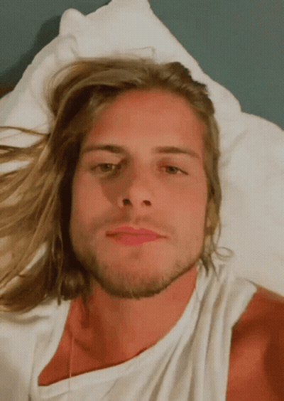 Man With Long Blonde Hair And Beard Laying On Bed GIF