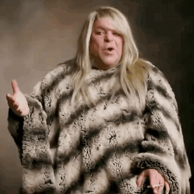 Man With Long Blonde Hair In Fur Coat GIF
