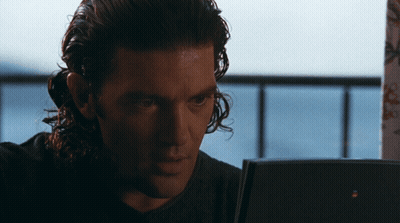 Man With Long Curly Hair Looking At Laptop GIF