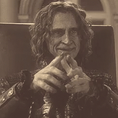 Man With Long Curly Hair Sitting In Chair GIF