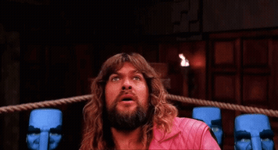 Man With Long Hair And Beard In Boxing Ring Surrounded By Blue Statues GIF