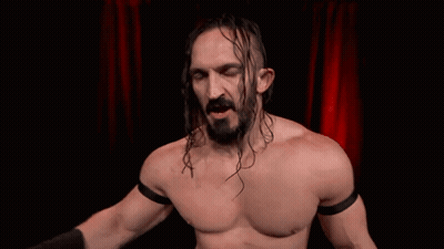 Man With Long Hair And Beard In Front Of Red Curtain Treated Like A Bum GIF